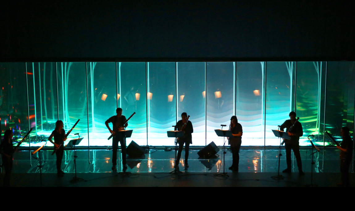 Ensemble in a mirrored, light-flooded space